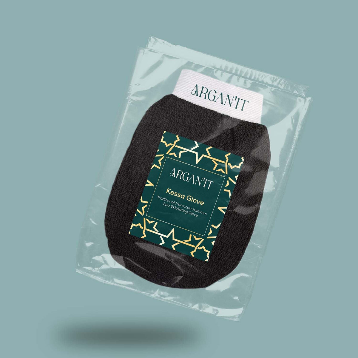 Packaged Arganit Moroccan Kessa exfoliating glove displayed at an angle on a muted teal background.